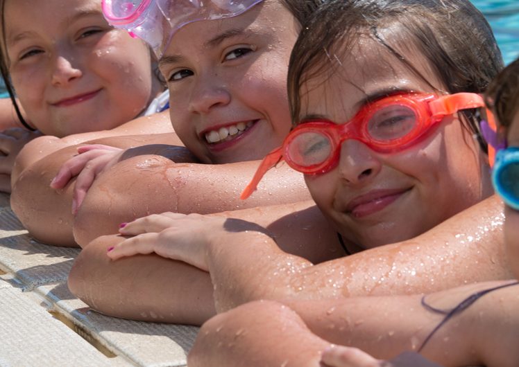 Four girls smiling in swimming pool